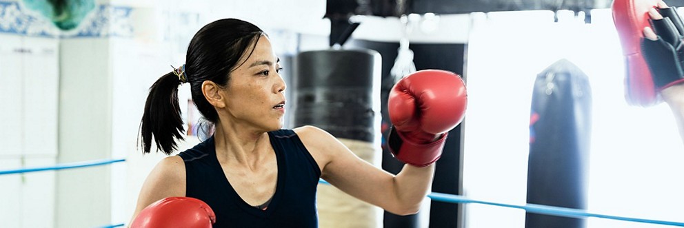 A young woman practices boxing.