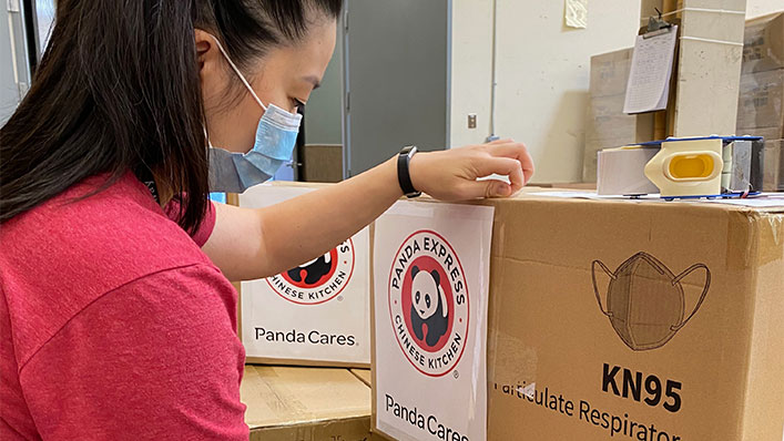 A Panda Cares Foundation employee packs boxes of KN95 masks.