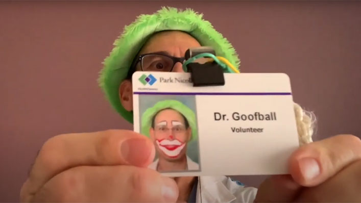 Dr. Goofball with his face painted like a clown proudly displays his volunteer badge.