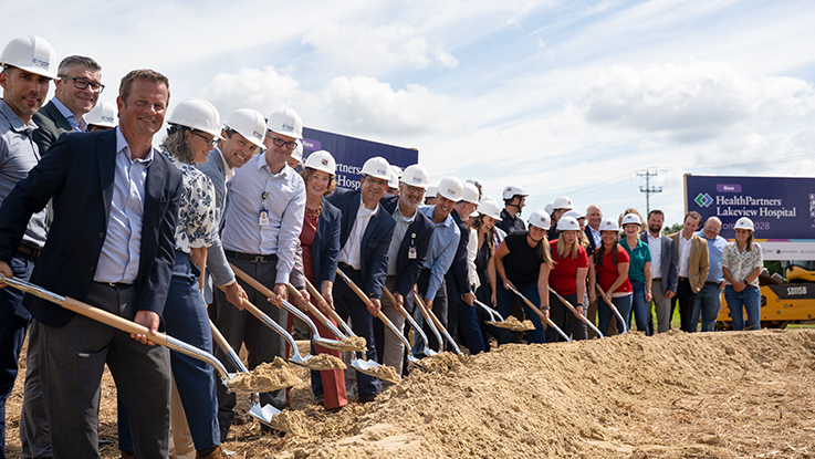 HealthPartners leaders wear hard hats and hold shovels at they break ground on the new Lakeview Hospital and HealthPartners Specialty Center. 