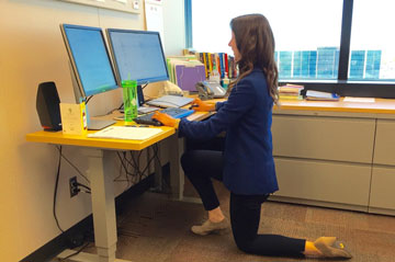 Woman kneeling at her desk
