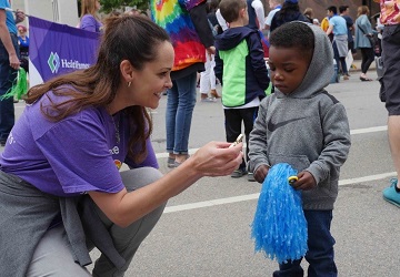 A woman wearing a HealthPartners shirt volunteers at the Twin Cities pride parade.