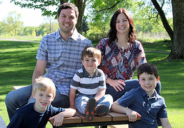 Renee Schwartz, her husband, and their three children sit on a picnic table outside