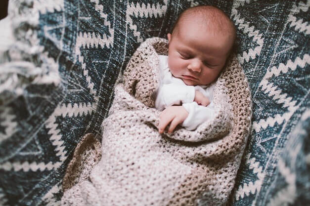 Baby Mila Ann Peterson naps in a blanket.