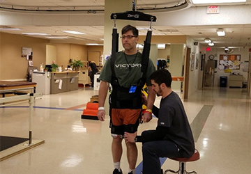 Matt works on taking steps during a physical therapy session at Regions.