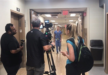 A camera crew films Dr. Sessions walking down a hallway at Regions Hospital. 